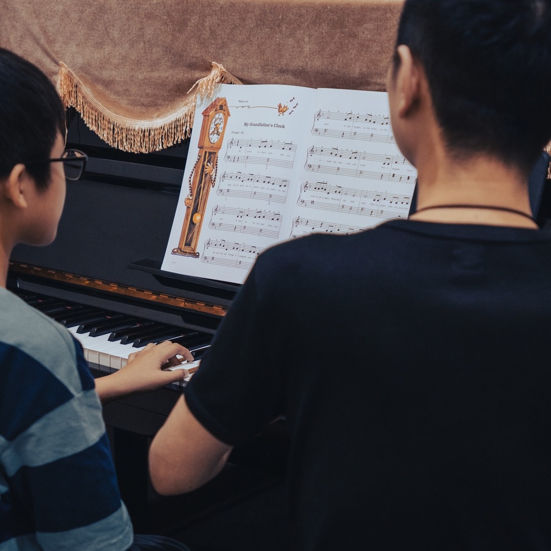 Piano teacher teaching children piano